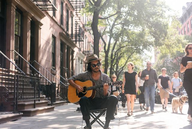 9:40 AM • West Village — Bleecker Street Melody: Street musician plays acoustic guitar on a sunny corner. Brownstones catch dappled light in true bohemian rhythm.